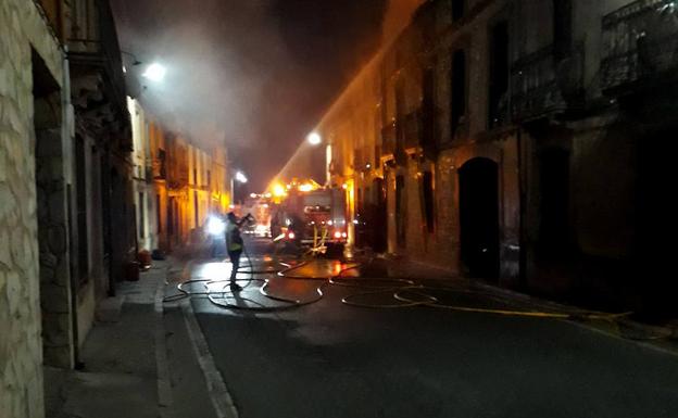 Los bomberos intervienen esta tarde-noche en las fachadas afectadas por las llamas en Fuenterrebollo. 