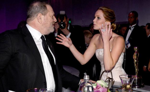 Jennifer Lawrence (d) habla con Harvey Weinstein en una fiesta. 