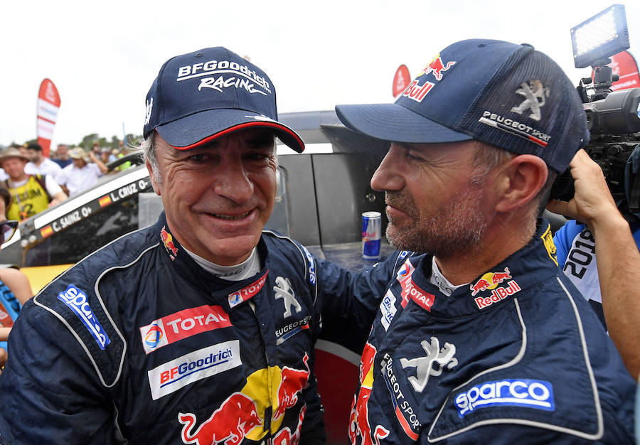 Carlos Sainz es felicitado por su compañero de equipo, Stéphane Peterhansel.