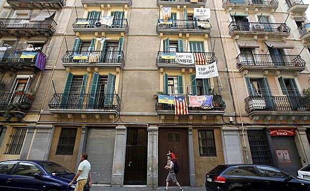 Varios vecinos de Barcelona cuelgan pancartas contra los alquileres turísticos. 