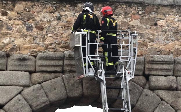 Los bomberos inspeccionan el murete superior del Acueducto.