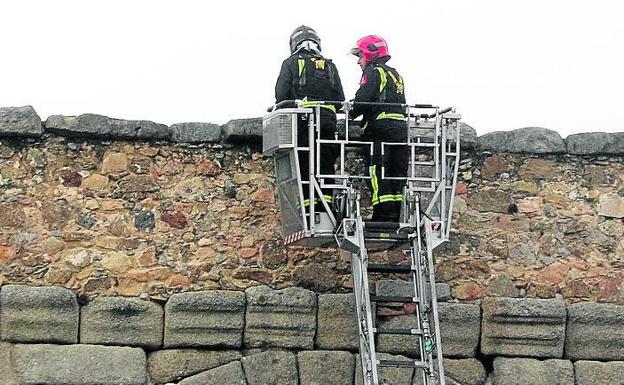 Los bomberos, durante la primera inspección tras la caída de la piedra. 