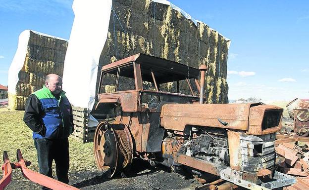 El ganadero Antonio Elizalde, junto al tractor y aperos que se quemaron en el incendio en su explotación de ovino.