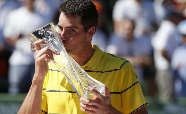 John Isner besa el trofeo. 