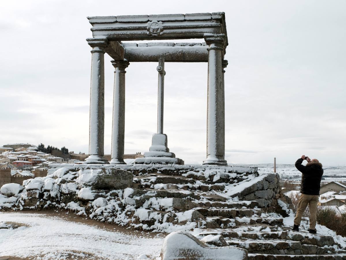 Un hombre toma una fotografía de los Cuatro Postes con la nieve caída durante la madrugada en la capital.