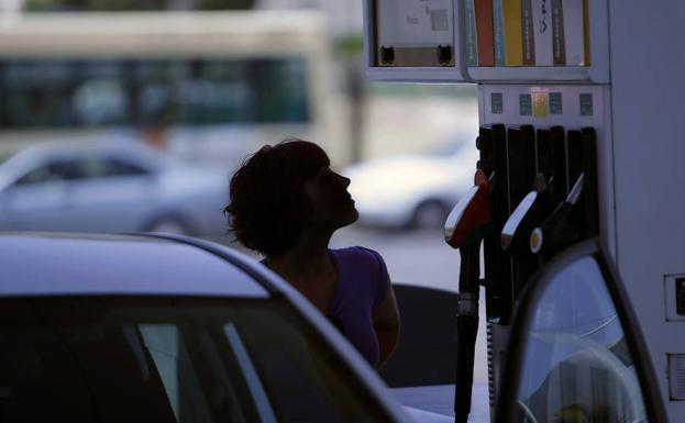 Una mujer reposta en una gasolinera.