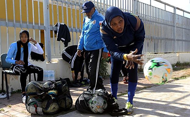 Una mujer prepara los balones para comenzar el entrenamiento. 