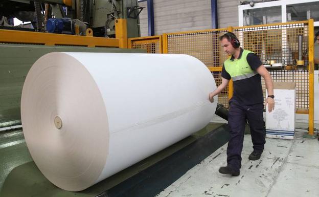 Un operario, junto a una bobina de papel estucado en la planta de Europac de Dueñas. 