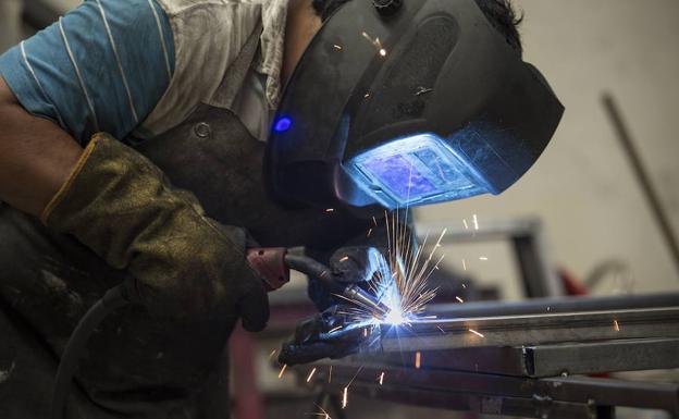 Un trabajador suelda dos piezas de metal.