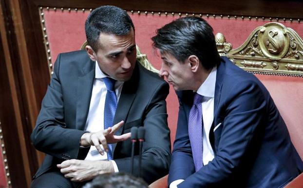 El presidente del Gobierno italiano, Giuseppe Conte (d), conversa con el ministro de Empleo, Luigi di Maio. 