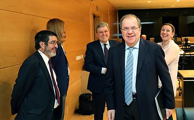 El presidente de la Junta, Juan Vicente Herrera, conversa con los procuradores de Ciudadanos, de Podemos y del PP antes de comparecer en la Comisión de Investigación de las Cajas de Ahorro. 