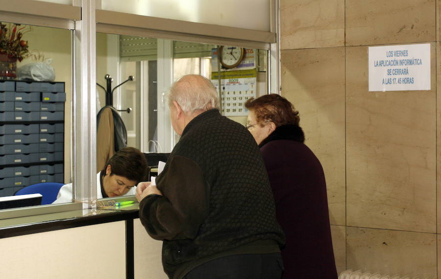 Dos personas mayores piden información en un Centro de Salud. 