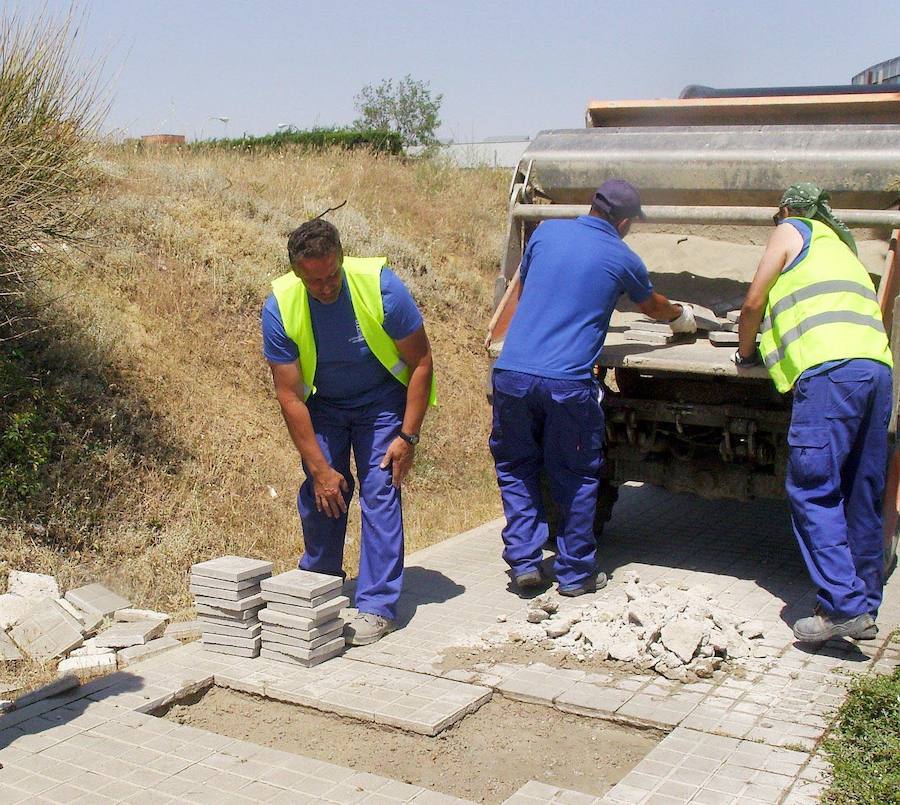 Una cuadrilla del Servicio de Vías y Obras trabaja en las aceras de la Carretera de La Granja en la ciudad de Segovia. 