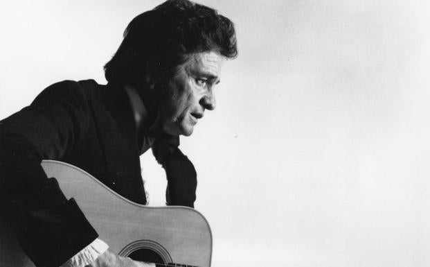 Johnny Cash toca la guitarra. 