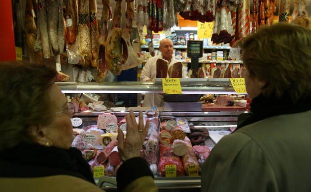 Dos mujeres hacen la compra en una charcutería.