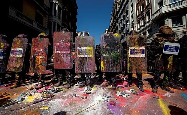 Agentes de los Mossos d'Esquadra cubiertos con pintura de colores.