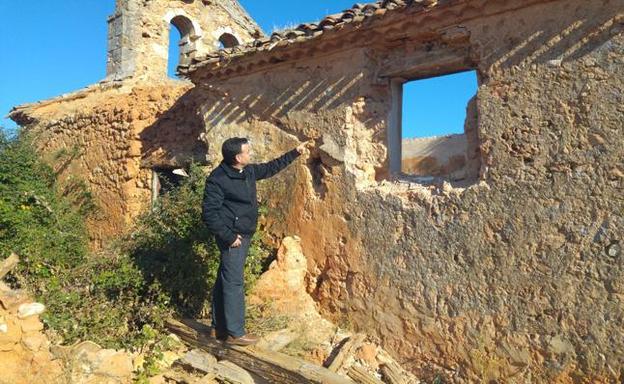 El párroco señala el lugar donde se encontraban las piezas de silleria robadas en la iglesia parroquial de Valdegrulla.