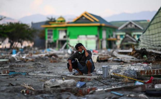 Un hombre descansa entre los escombros de Palu. 