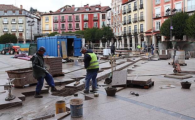 Dos obreros trabajando en la Plaza Mayor de Burgos.
