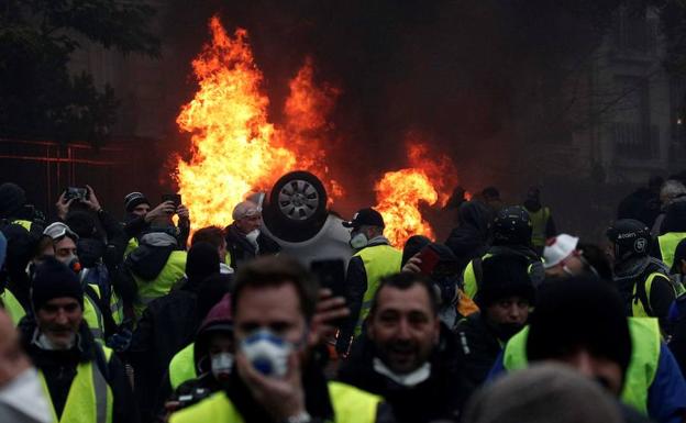 Manifestantes con chalecos amarillos se enfrentan a la policía cerca del Arco del Triunfo de París. 