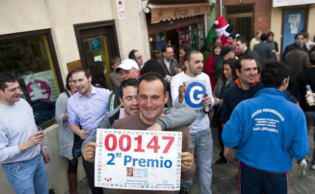 Varias personas celebran a las puertas del bar 'African', situado en la Plaza Mayor de Roa el segundo premio del Sorteo de Lotería de Navidad. 