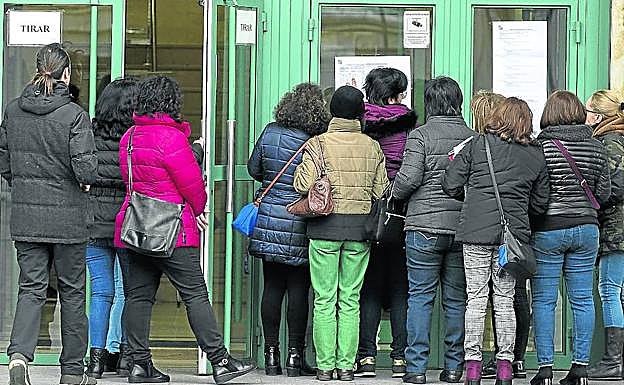 Varios aspirantes a una plaza de personal de servicio consultan los listados en el Aulario de la Universidad de Valladolid, el pasado domingo.