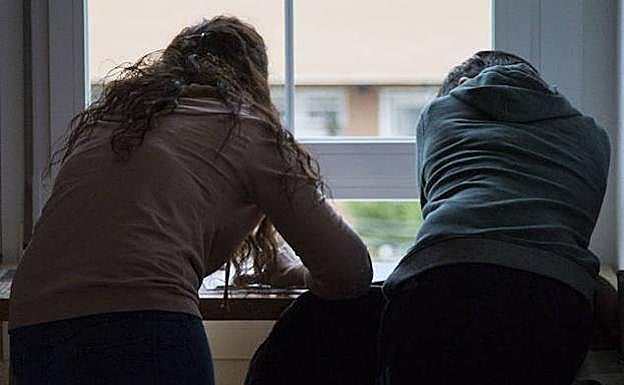 Una educadora repasa los deberes con uno de los menores. 