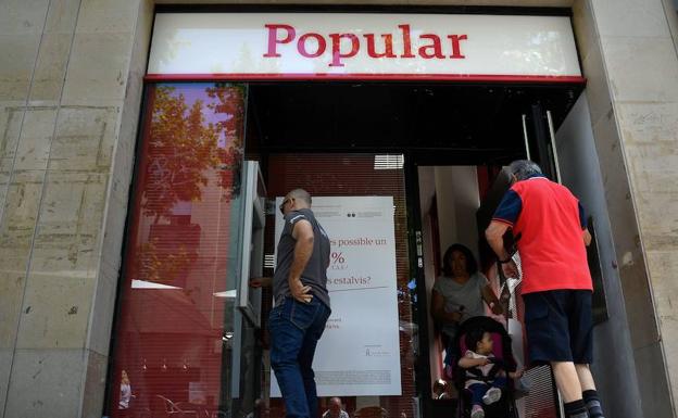 Clientes sacan dinero de una sede del Banco Popular. 