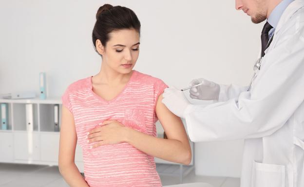 Un médico administra una vacuna a una paciente. 