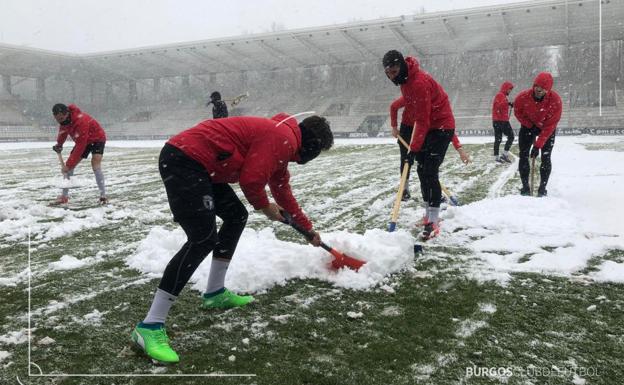 La plantilla del Burgos CF retira la nieve que impedía que utilizaran esta mañana El Plantío