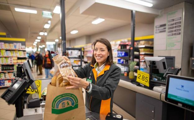 Una dependienta de Mercadona introduce la compra en una bolsa de papel reciclado.