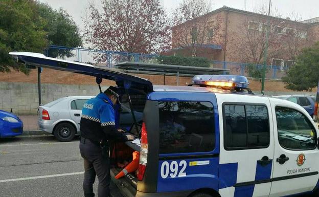 Un agente del equipo de Atestados realiza el test de drogas al conductor del autobús escolar a las puertas de un instituto de Valladolid. 