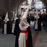 La túnica y el capirote son de color blancos, el fajín, rojo y la capa, negra.