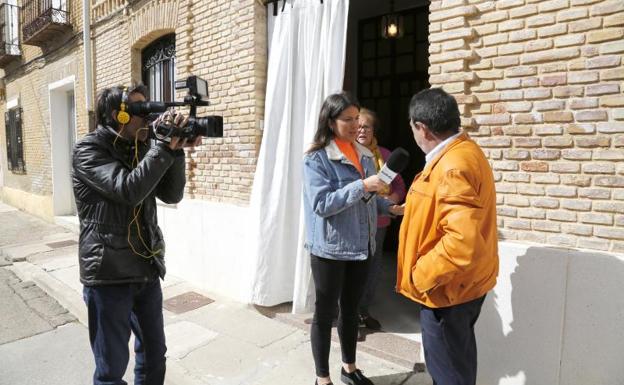 El marido de Iris, una de las vecinas que ha recibido un sobre, habla con una reportera de la televisión nacional sobre el suceso. 