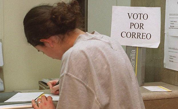 Una joven rellena la documentación para votar por correo.