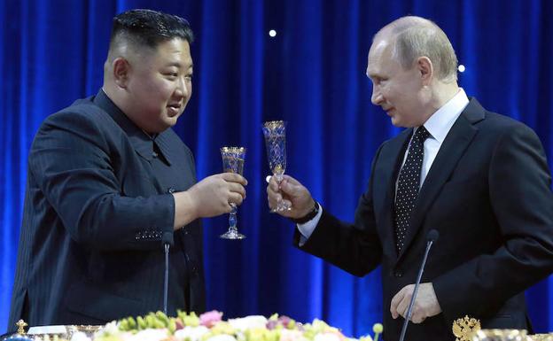 Kim Jong-Un (i) brinda con Putin. 