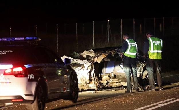 Dos agentes de la Guardia Civil observan el estado en el que quedó uno de los vehículos implicados en el accidente. 