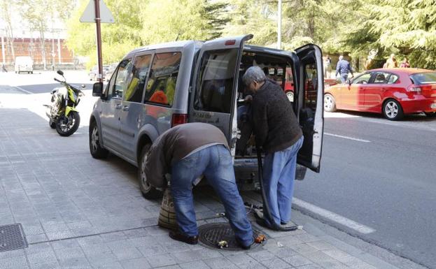 El padre y uno de los hijos de la familia desahuciada meten sus enseres en una furgoneta. 