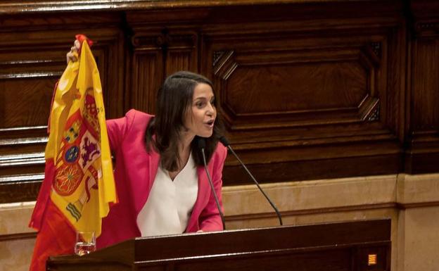 Imagen principal - Arrimadas porta una bandera de España en el Parlament (Arriba); La diputada de la CUP, Natalia Sánchez , coloca un cartel con el lema «Stop Fascim» ante la líder de Ciudadanos (izq.); Arrimadas interpela al presidente de la Generalitat, Quim Torra, durante la sesión de control al Govern (dcha.). 