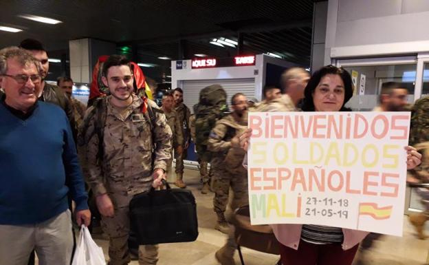 Dos padres reciben al sargento especialista Roberto López, de Arévalo, en la madrugada del miércoles en Barajas. 