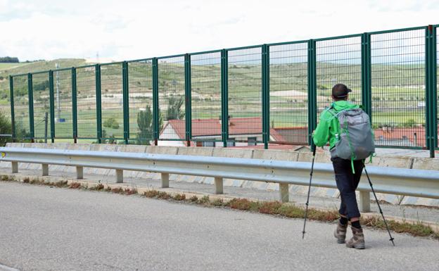 Un peregrino transita por la carretera del puente