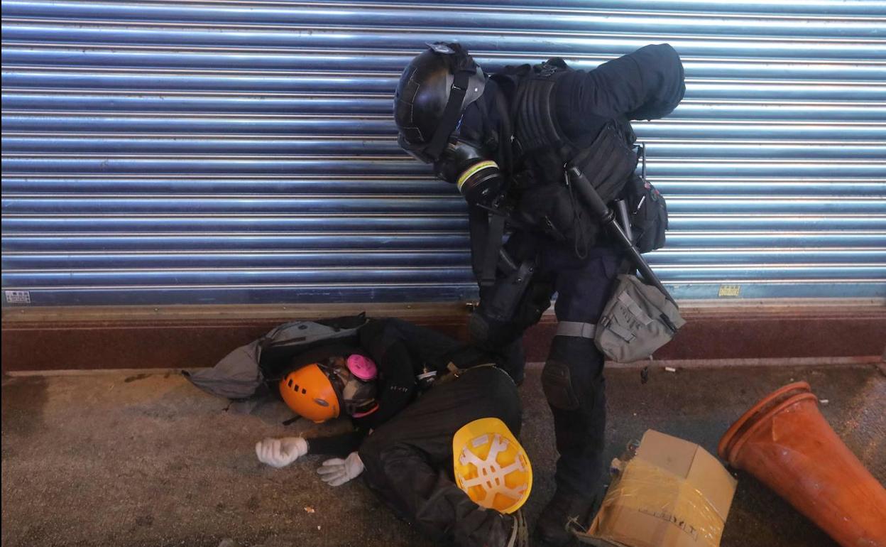 Un manifestante es detenido por la policía en Hong Kong.