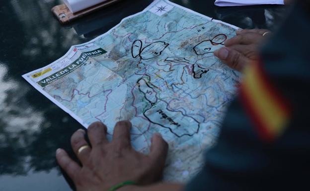 Un agente de la Guardia Civil muestra un mapa perimetrado en las zonas en las que se busca a la exdeportisa.
