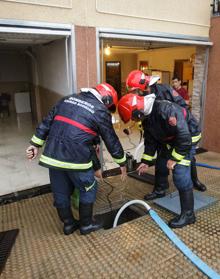 Imagen secundaria 2 - Vecinos y bomberos trabajan para limpiar calles y garajes.