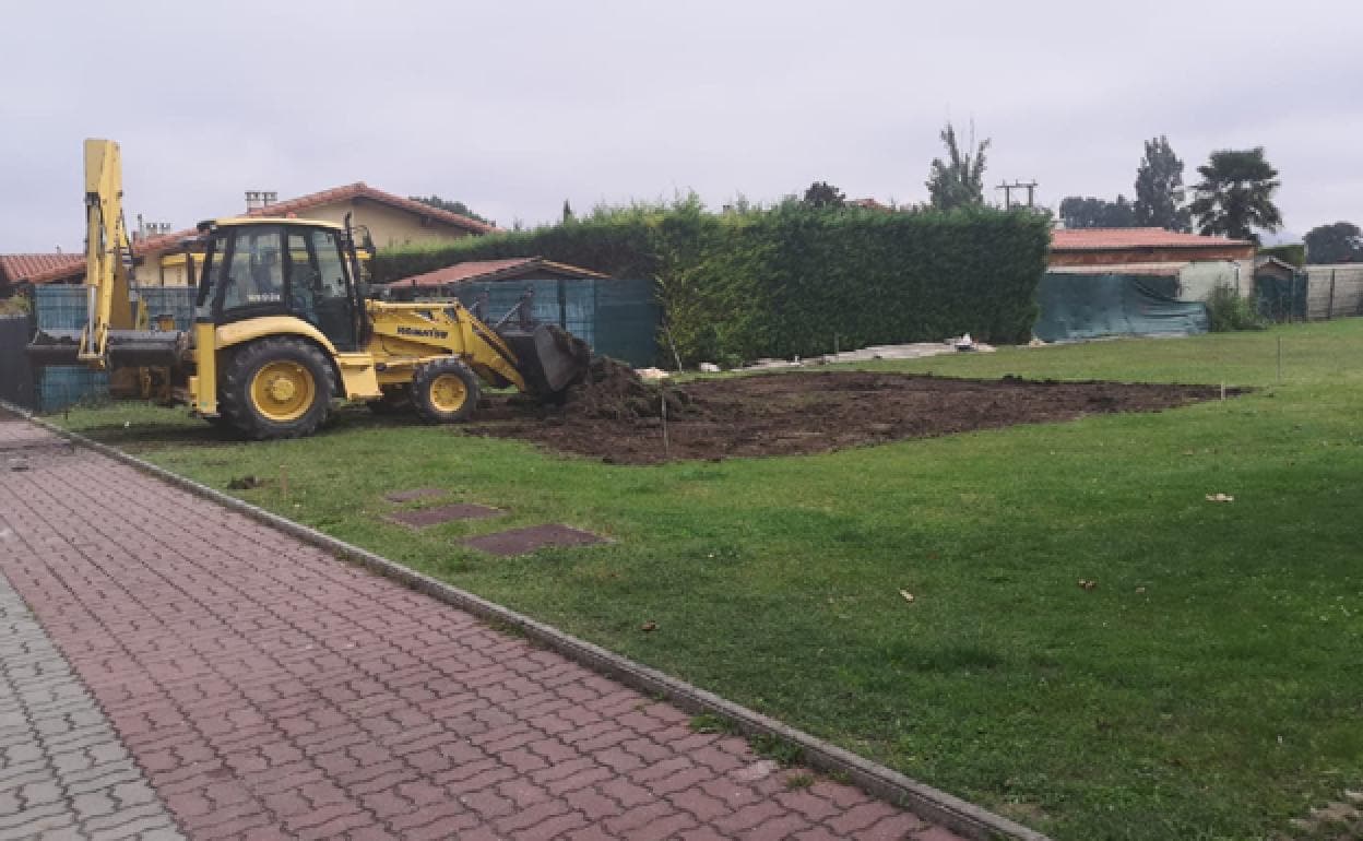 Una excavadora trabaja en la zona destinada al parque infantil. 