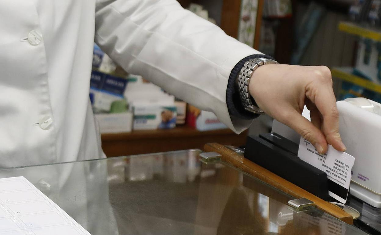 Una farmacéutica pasa la receta electrónica. 