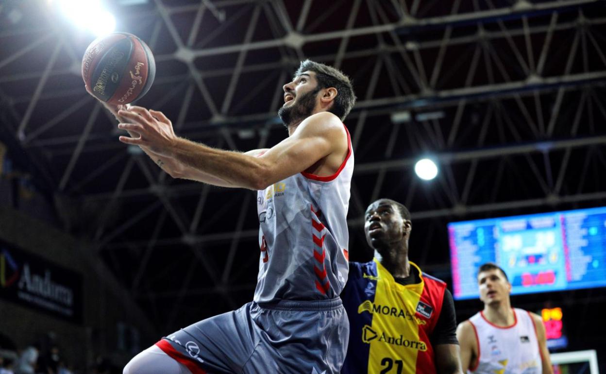 Álex Barrera entrando a canasta ante la defensa del Moussa Diagne. 