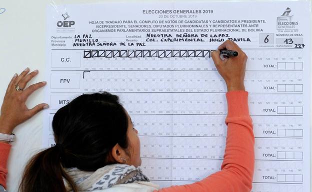 Una mujer participa en el escrutinio en una mesa electoral durante las elecciones presidenciales en La Paz (Bolivia).