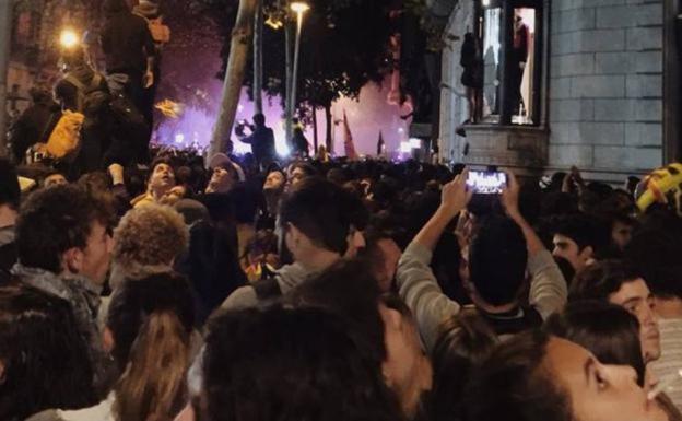 Imagen principal - Arriba, los manifestantes graban los disturbios bajo la casa de Alicia. Abajo, a la izquierda, adoquines arrancados para usarlos como proyectiles junto al portal de la casa en la que reside la palentina. Abajo, a la derecha, varias personas tratan de colocar un contenedor en medio de la calle en una imagen tomada desde la casa de Alicia. 