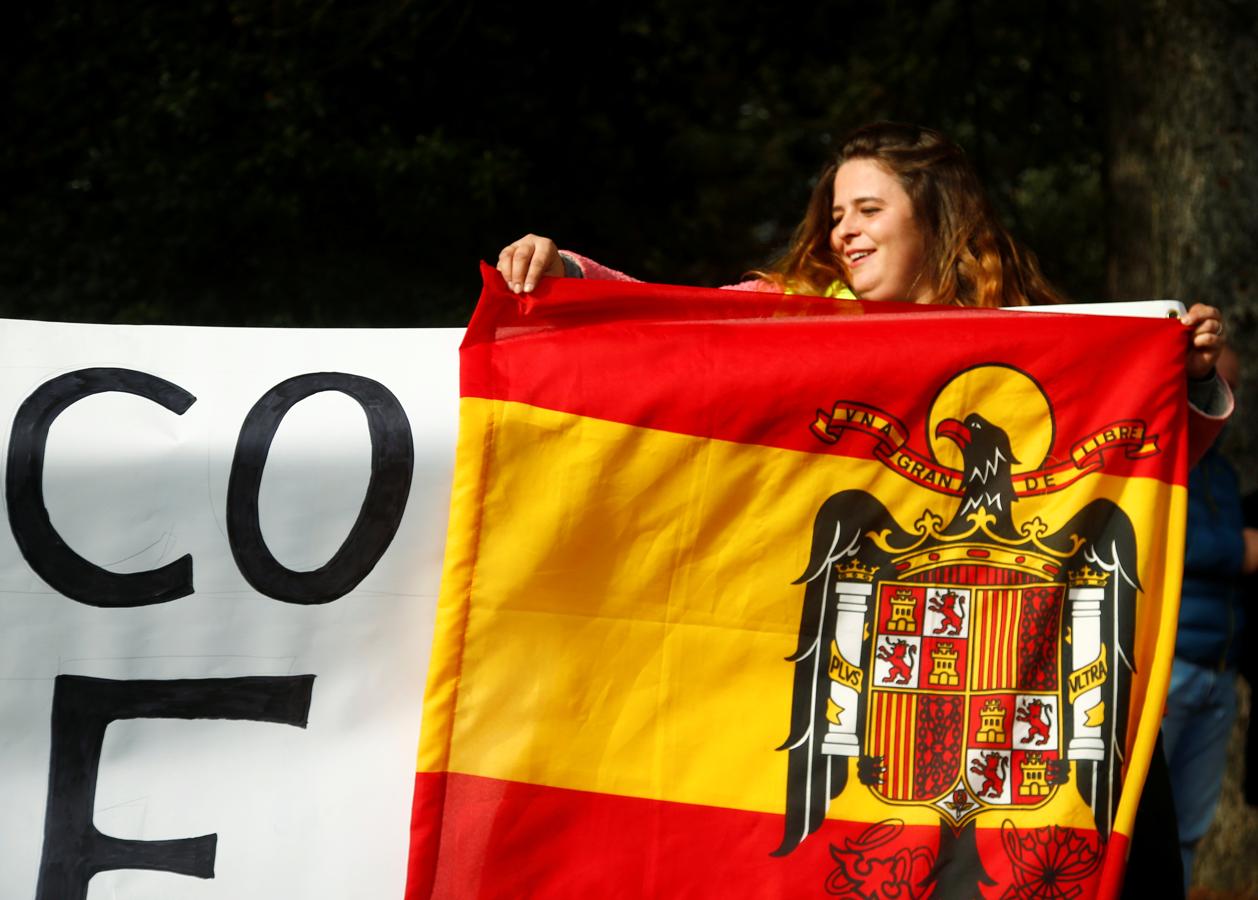 Una simpatizante de Franco coloca una bandera preconstitucional a la entrada del Valle de los Caídos.